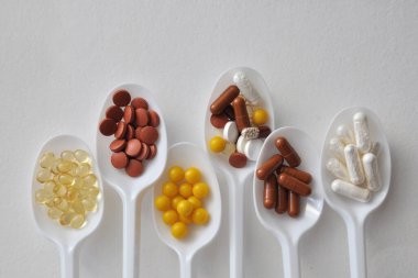 Tabletler, kapsüller, beslenme takviyeleri, kaşıklarda vitaminler. Tıbbi geçmiş