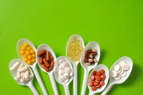 Tabletler, kapsüller, beslenme takviyeleri, kaşıklarda vitaminler. Tıbbi geçmiş