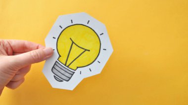 Üzerinde ampul deseni olan bir konuşma balonu. Yaratıcı bir fikrin ortaya çıkmasının sembolü.