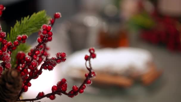 緑のモミの枝にある赤い果実から おいしいクリスマスケーキやホットティーまで テーブルの上や後ろに集中してください 人のいない屋内での休日のお正月の装飾と甘いデザート — ストック動画