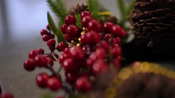 现场摄像头沿着红色浆果和绿色松枝在室内移动 除夕之夜没有人的传统圣诞装饰品 — 图库视频影像