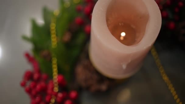 Nahaufnahme Brennende Weihnachtskerze Zeitlupe Mit Grünem Tannenzweig Und Roten Beeren — Stockvideo