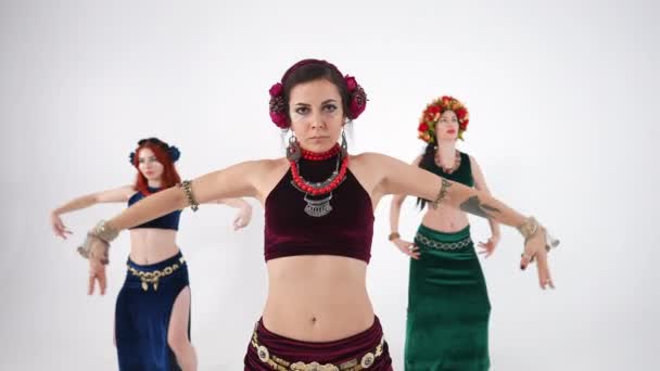 有自信 有才华的女人的画像 她们的胸部和双手在慢动作中移动 在白色背景下表演中东舞 三个白人表演者跳肚皮舞 — 图库视频影像