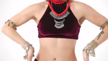 Orta ölçekli, tanınmayacak kadar zayıf bir kadın göbek dansı yapıyor ve ağır çekimde ellerini hareket ettiriyor. Beyaz arka planda dans eden Kafkasyalı sanatçı