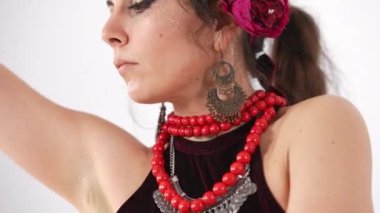 Beyaz arka planda göbek dansı yapan kendine güvenen beyaz bir kadın. Yetenekli zarif bayan dans ediyor Orta Doğu dansı ağır çekimde