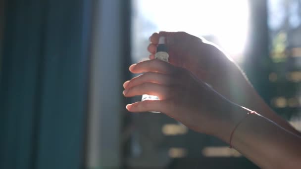 在室内阳光下 女性的手在棕榈皮上洒香水 难以辨认的年轻白人女人早上在家里准备放香水 — 图库视频影像