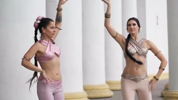 两名才华横溢的美女同时摇着肩膀在户外表演印度舞曲 有自信的华丽演员在城市里排成纵队 微笑着跳舞 — 图库视频影像
