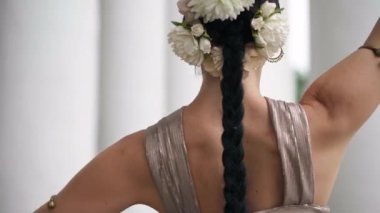 Zarif, muhteşem bir kadın Hint dansı yapıyor. Hareket eden vücudu başka yöne çeviriyor. Kentteki büyük beyaz sütunlarda dans eden kendine güvenen güzel bir kadının portresi.