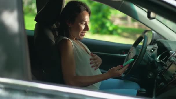 Szczęśliwa Kobieta Ciąży Wiadomości Online Aplikacji Smartphone Siedzi Fotelu Kierowcy — Wideo stockowe