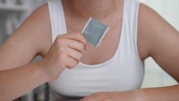 无法辨认的白人年轻女子坐在室内 身上带着痘痘疹 带着避孕套 有发痒病毒点的女士做性保护广告 感染和药物概念 — 图库视频影像