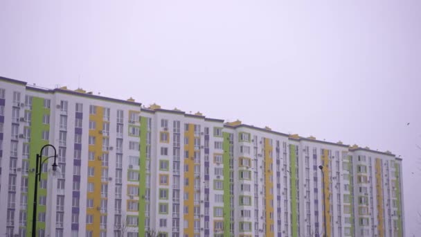 Vícepodlažní Obytná Budova Barevnými Zdmi Pozadí Zatažené Zimní Oblohy Prolétávajícími — Stock video