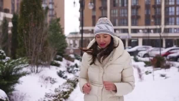冬の屋外休暇中にジョギング満足フィットスポーツウーマンのドリーショットの肖像画 フロントビューやる気雪の日にトレーニングを行って自信を持って美しい白人女性 — ストック動画