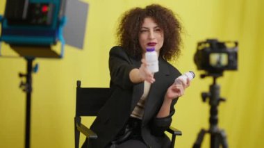 Güzel genç bir kadın vitamin reklamlarından bahsediyor sarı arka planda video blogu çekiyor. Kafkas sağlık blogu kayıt edicisinin portresi sağlıklı yaşam tarzını destekliyor