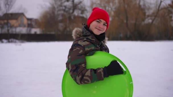 Zoom Portrait Smiling Teenage Boy Posing Slow Motion Green Sled — Vídeo de Stock