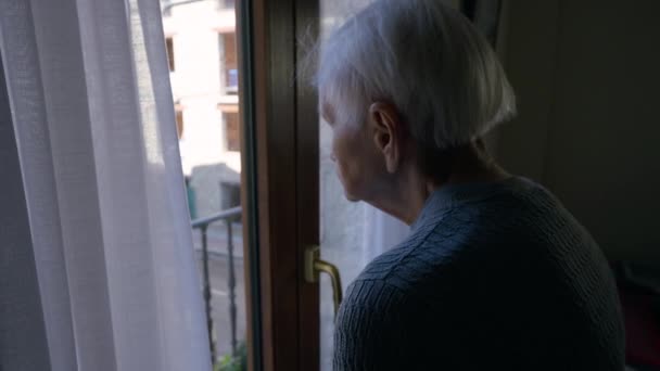 Frustrated Lonely Caucasian Old Woman Standing Balcony Door Looking Out — Stockvideo