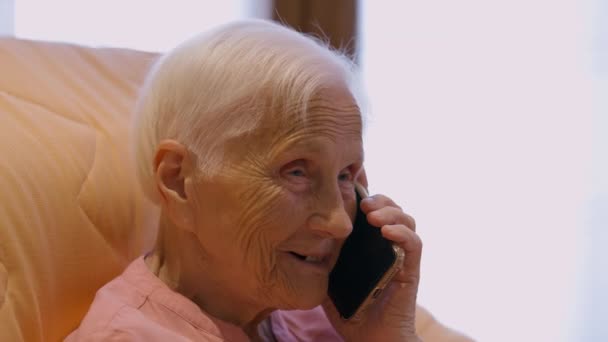 Счастливая Пенсионерка Смеется Разговаривая Телефону Сидя Дома Портрет Радостной Кавказской — стоковое видео