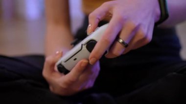 Close-up slim young female hands using joystick playing multiplayer video game. Unrecognizable absorbed concentrated confident Caucasian woman gaming online indoors at home on weekend