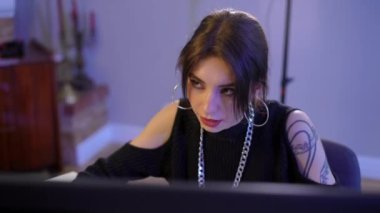 High angle view of concentrated gorgeous young slim woman talking gaming online on PC. Portrait of beautiful confident focused Caucasian gamer playing video game discussing strategy