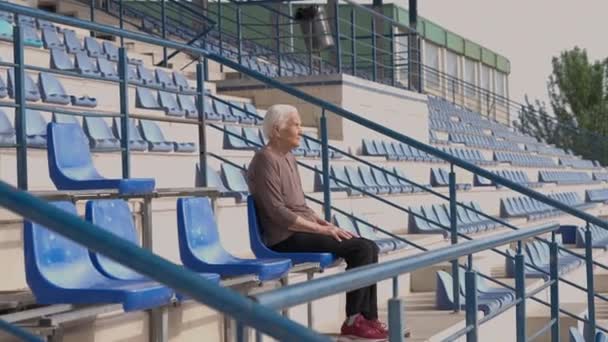 Wide Shot Outdoor Stadium Sunshine Old Gray Haired Woman Sitting — стокове відео
