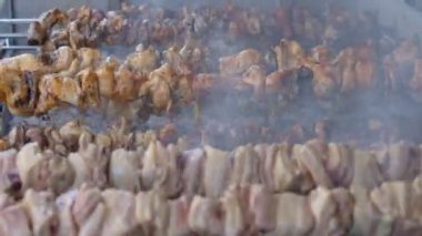 Etli şişler dışarıda yuvarlanıyor ve kadın eli kömürleri ayarlıyor. Tanınmayan satıcı, Kıbrıs 'ta sokak pazarında lezzetli geleneksel yemekler pişiriyor.