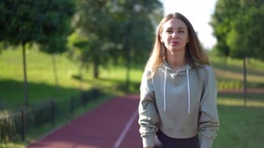 Kendine güvenen genç bir kadın gün ışığında kaçmaya başlarken canlı kamera görüntülerini izliyoruz. Yazın açık havada güneşli parkta antrenman yapan güzel beyaz kadın.