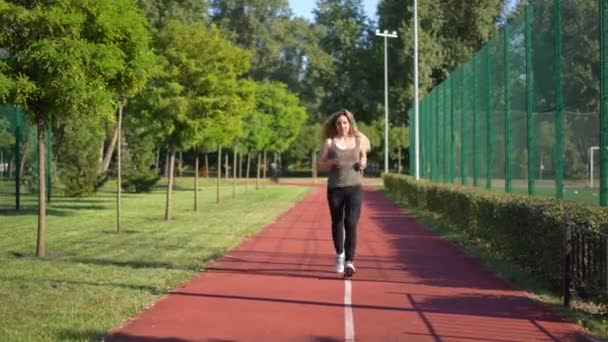 Szeroki Strzał Pewna Siebie Zmotywowana Biała Młoda Kobieta Biegająca Torze — Wideo stockowe