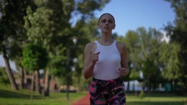 Açık havada ağır çekimde koşan ve ayrılan zayıf, genç bir sporcunun portresi. Güneşli bir günde spor yapan Kafkasyalı genç bir kadının Dolly çekimi. Spor ve yaşam tarzı kavramı
