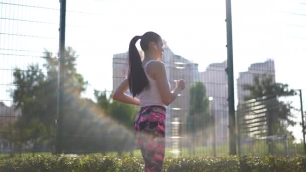 Widok Boku Pasuje Młodych Sportowców Biegających Wzdłuż Siatki Ogrodzenia Słońcu — Wideo stockowe