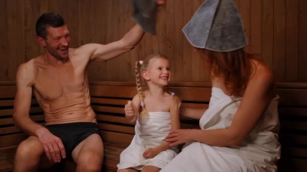 Lykkelig Datter Som Spiller Steinsaks Med Foreldre Trebenk Finsk Sauna – stockvideo