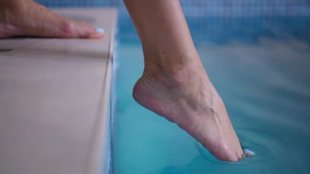 Крупным Планом Женская Нога Касается Голубой Воды Бассейне Помещении Неузнаваемая — стоковое видео