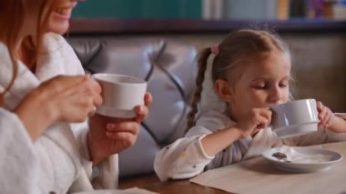 Mutlu kız ve kadın SPA restoranında oturup çay içerek sohbet ediyorlar. Kendine güveni tam, Kafkas kızı ve annesi evde gülümseyerek hafta sonunun tadını çıkarıyor.