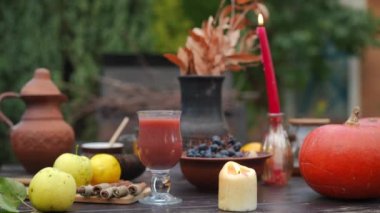 Açık havada yanan mumlarla dolu bir masa organik vitaminli meyve ve sebzeler. Bahçede sonbahar günü yiyecek ve içecek.