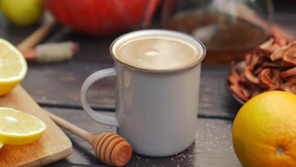 屋外のテーブルの上にコーヒーココアとカップに牛乳を注ぐクローズアップ 秋の日に美味しいお酒を作る無名の人 — ストック動画