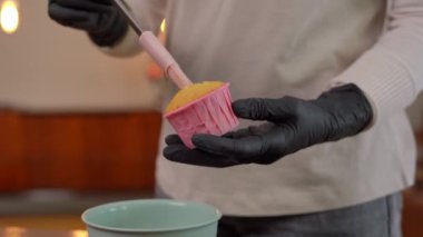 Pasta fırçasıyla pişmiş kekin üzerine beyaz tatlı sıvı döken tanınmayan bir kadın. Beyaz bir ev hanımı evde lezzetli bir tatlı pişiriyor.