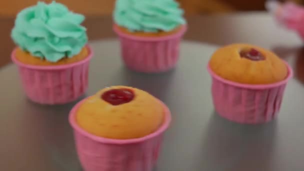 Vier Muffins Mit Roter Marmelade Und Grünem Zuckerguss Auf Tablett — Stockvideo