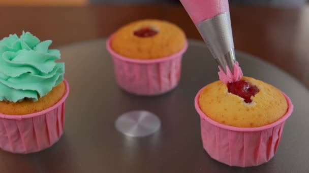 Zbliżenie Wylewając Różowy Lukier Torby Ciasta Muffinkę Wewnątrz Nierozpoznawalny Piekarz — Wideo stockowe