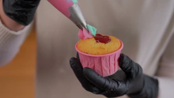 Szoros Női Kéz Kesztyűben Vajkrém Cukormázat Öntve Muffinra Sokszínű Rózsa — Stock videók