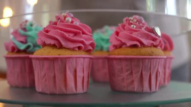 Yakın plan kaplama, cam kapaklı ve tepside dönen dekore edilmiş kekler. Ev yapımı fırında kraliyet kreması ve yenilebilir incilerle yakın plan lezzetli hamur işi.