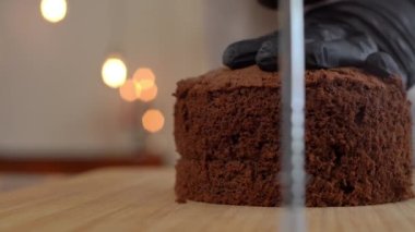 Kapalı mekanda çikolatalı pasta kalıbını kesiyorum. Tanımlanamayan kadın fırıncı eldivenli lezzetli tatlılar pişiriyor.