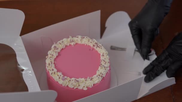 粉红可口的蛋糕 用女性的手把食物器皿放在关闭纸盒的小盒子里 难以辨认的小业主包装美味的甜点 在室内高角度销售 — 图库视频影像
