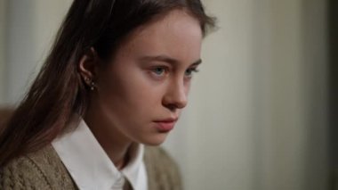 Yakın plan depresif beyaz kız aşağı bakıyor ve içeri bakıyor. Hüsrana uğramış umutsuz bir gencin yakın plan portresi.