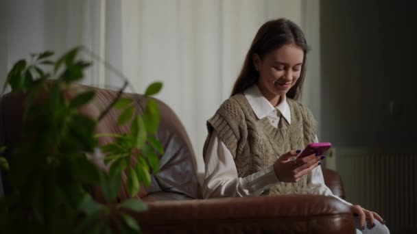 Портрет Счастливой Девочки Подростка Сидящей Онлайн Приложении Смартфона Улыбающейся Отводя — стоковое видео