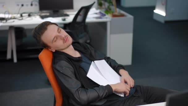 精疲力竭的男人躺在写字楼的办公椅上睡觉的画像 工作场所的白种人男性员工文件过多 负担过重 疲劳和过度劳累的概念 — 图库视频影像