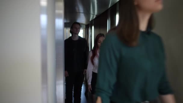 三名年轻的白人雇员走出电梯 离开室内 严肃而自信的男女就任公职的画像 — 图库视频影像