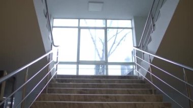 Binadaki merdivenler, arka planda büyük bir pencere var. Geniş açılı boş mekanlar ve hiç insan yok.