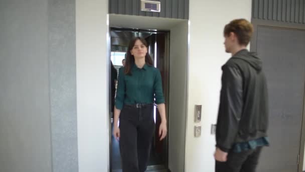 女人从电梯旁边走过 男人慢吞吞地走进电梯 有信心的白种人年轻雇员在室内的商业办公室 — 图库视频影像