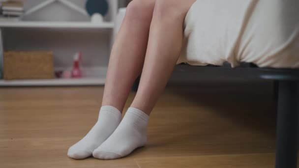 알아볼 수없는 여자가 침대에 다리를 걸어간다 양말을 아침에 집에서 일어나 — 비디오
