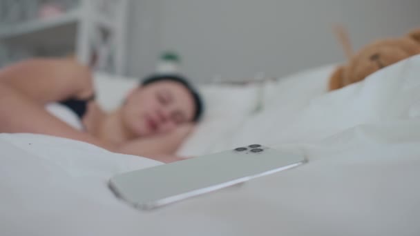 Szczelny Smartfon Białym Przytulnym Łóżku Rozmytą Kobietą Odbierającą Rano Telefon — Wideo stockowe