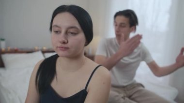 Genç, çaresiz bir eş, el hareketleriyle yardım için işaret veriyor kameraya öfkeli bir koca gibi bakıyor ve arka planda tartışıyor. Depresyonda olan beyaz bir kadının portresi ve yatak odasında bir erkek.