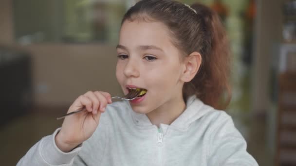 Brunetka Dziewczyna Brązowymi Oczami Jedząca Smaczne Pierogi Zadowolonym Wyrazem Twarzy — Wideo stockowe